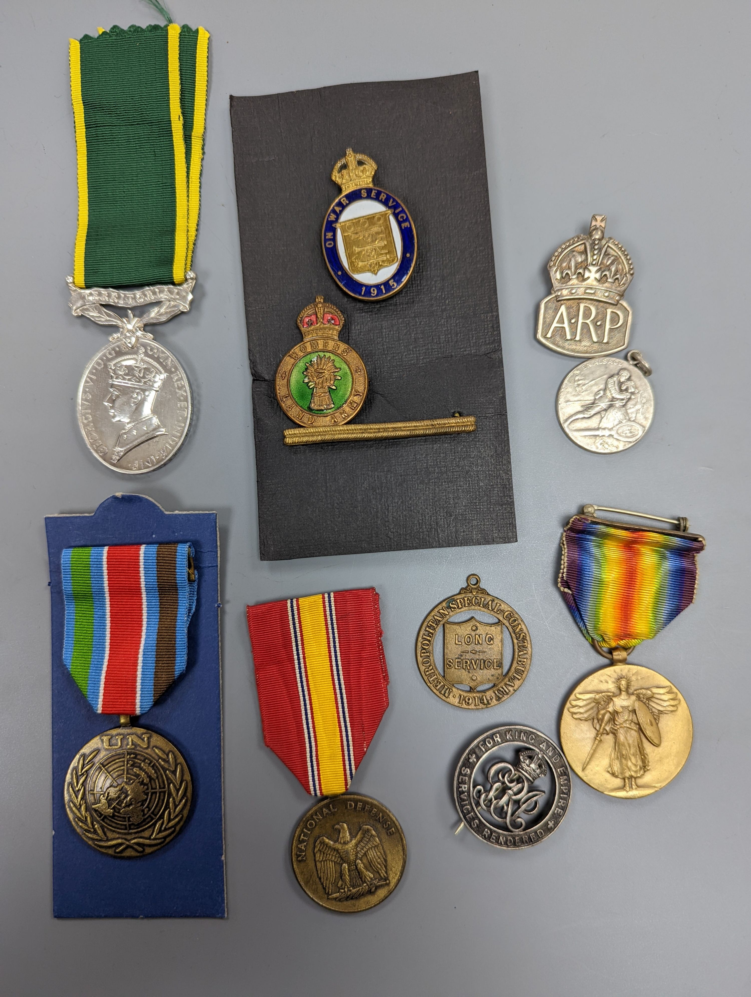 A George VI Territorial For Efficient Service medal, ARP, On War Service, Women’s Land Army badges, UN medal and other badges and medals and a quantity of reference books